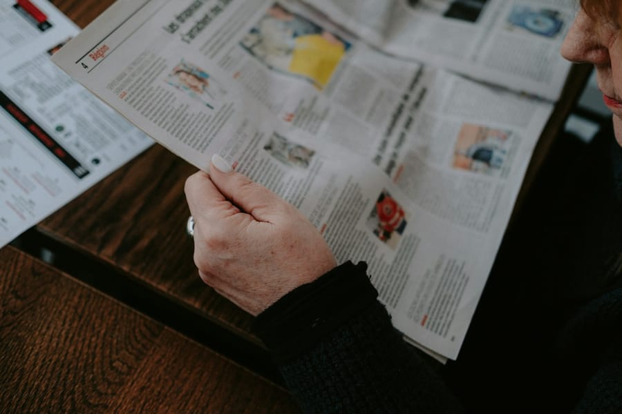 Gazetede sonuç sayfasını okuyan kişi